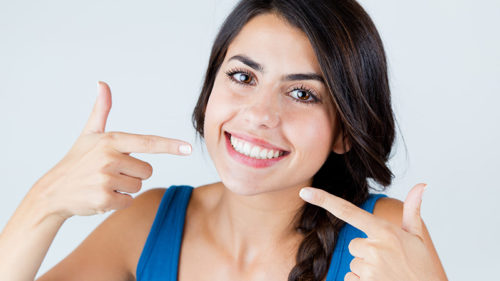 Smiling girl pointing at her teeth